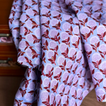 Folded fabric with a floral pattern in front of a wooden drawer.