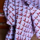 Folded fabric with a floral pattern in front of a wooden drawer.